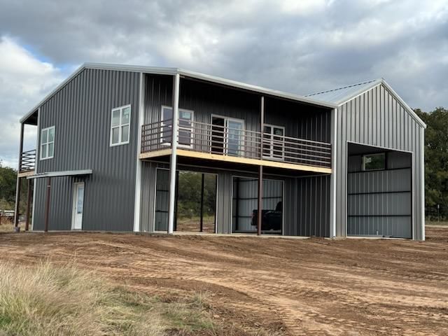 A large metal building with a balcony and a garage.