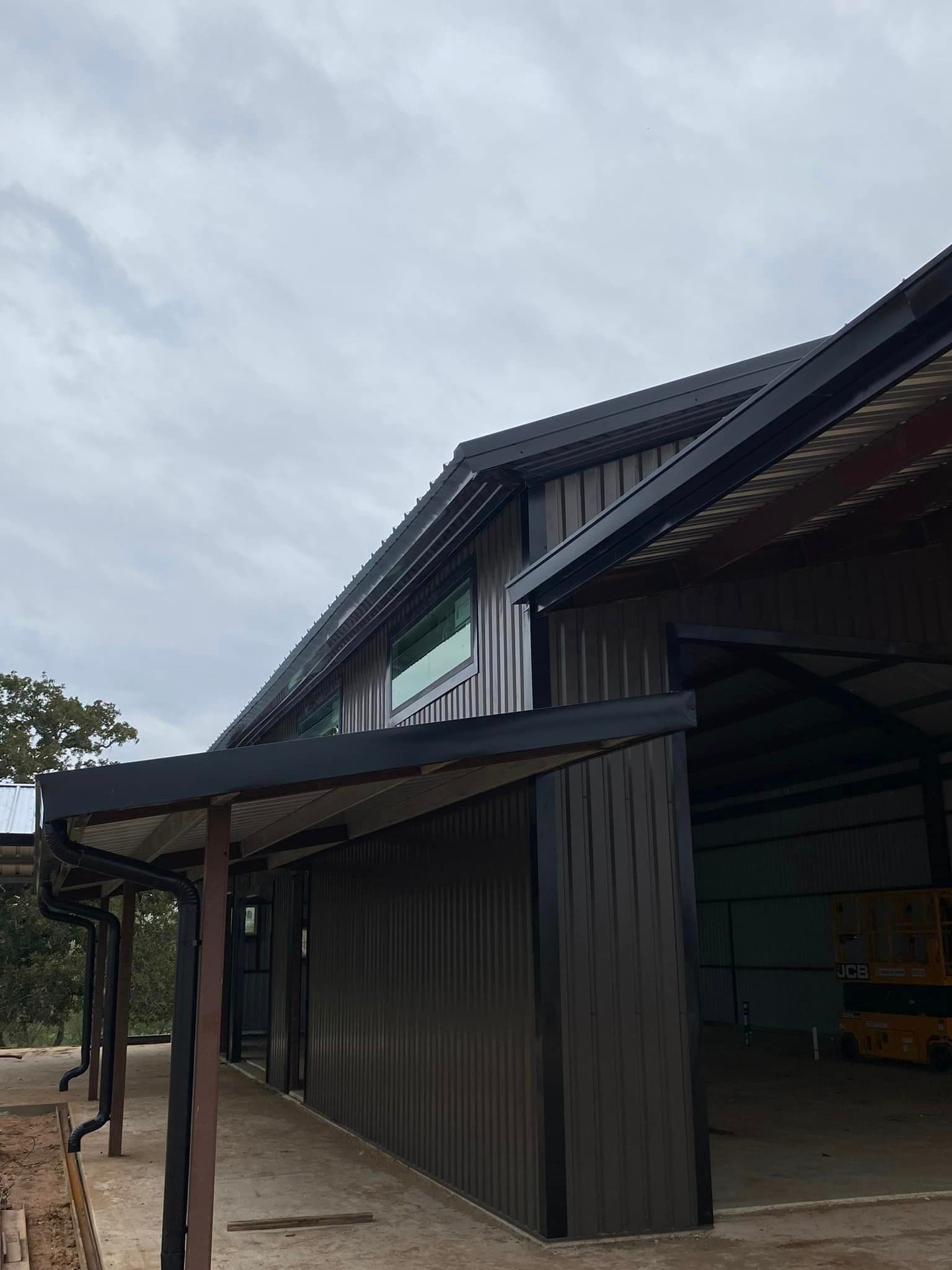 A large metal building with a covered area underneath it.
