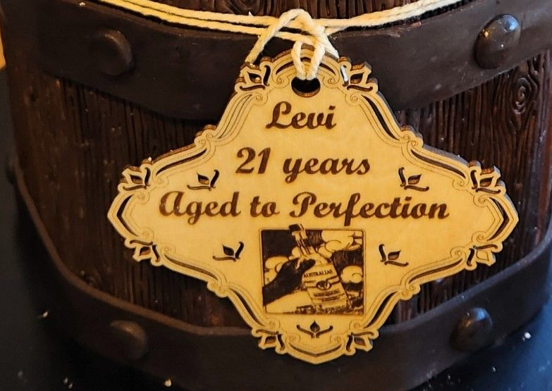 Wooden tag on a barrel cake, reads 