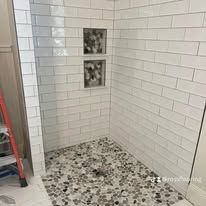 A custom tile shower installation in a bright modern bathroom with clean grout lines and neutral tones.