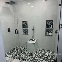 A custom walk-in shower with large tile walls, frameless glass, and a clean modern finish.