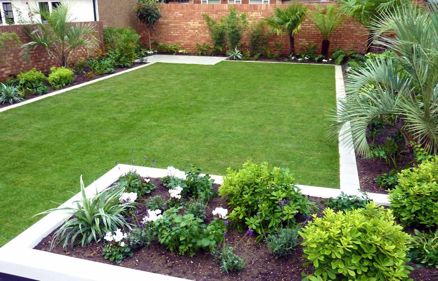 A garden with a lush green lawn and lots of plants