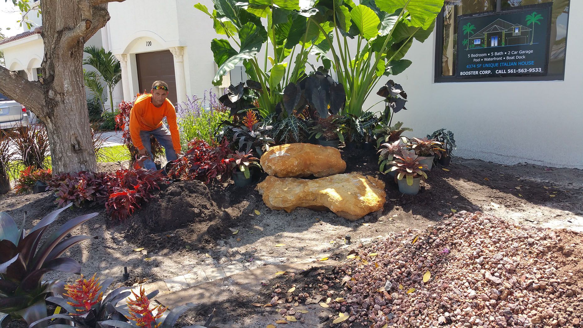 A man is standing in a garden in front of a house.