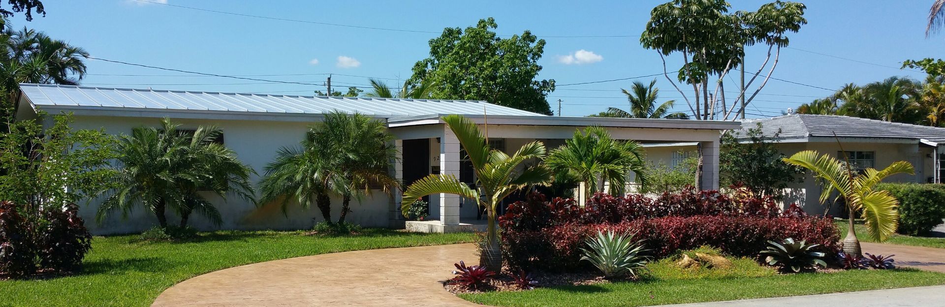 A house with a lush green lawn and trees in front of it.