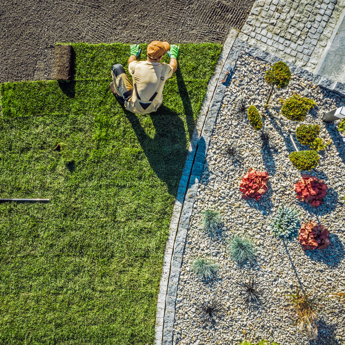 An aerial view of a man sitting on top of a lush green lawn.