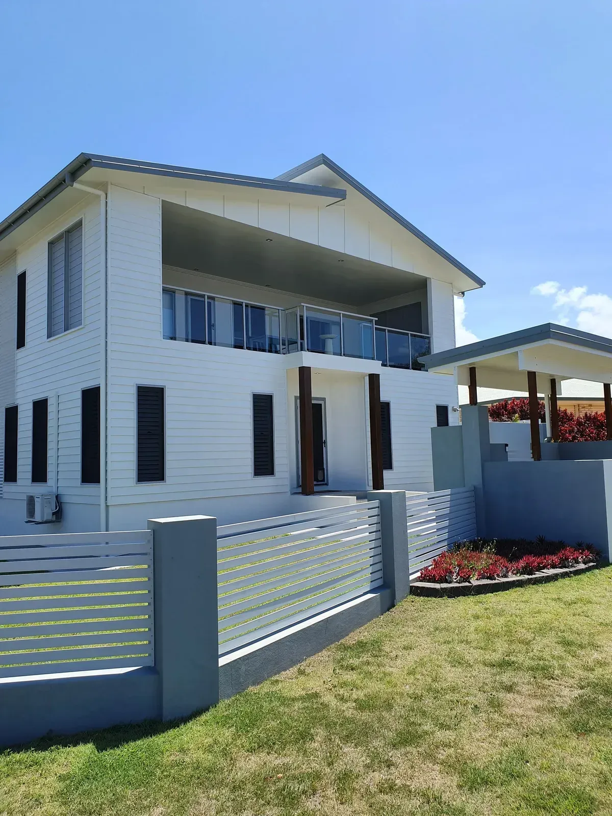 White Two-story House With Balcony, Glass Railings — Keppel Coatings in Pacific Heights, QLD