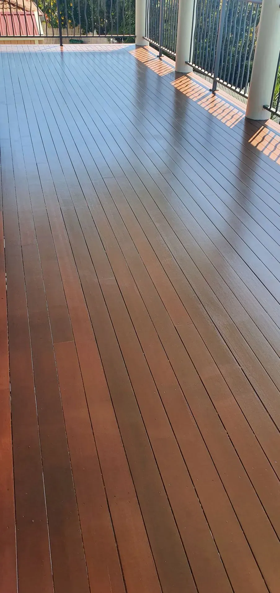 Wooden Deck With Diagonal Grooves and White Pillars — Keppel Coatings in Pacific Heights, QLD