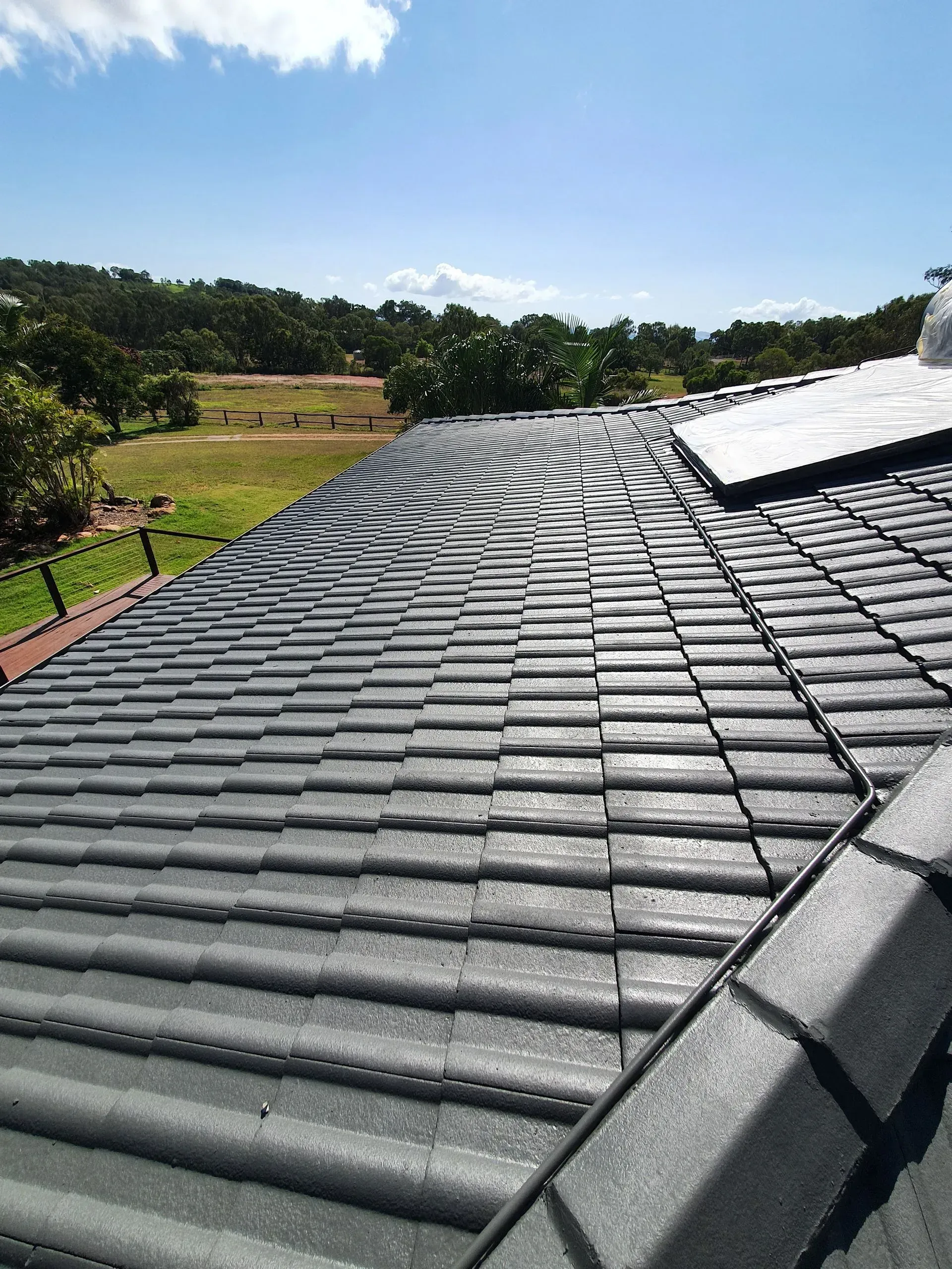 Gray Tiled Roof With Curved Ridges — Keppel Coatings in Pacific Heights, QLD