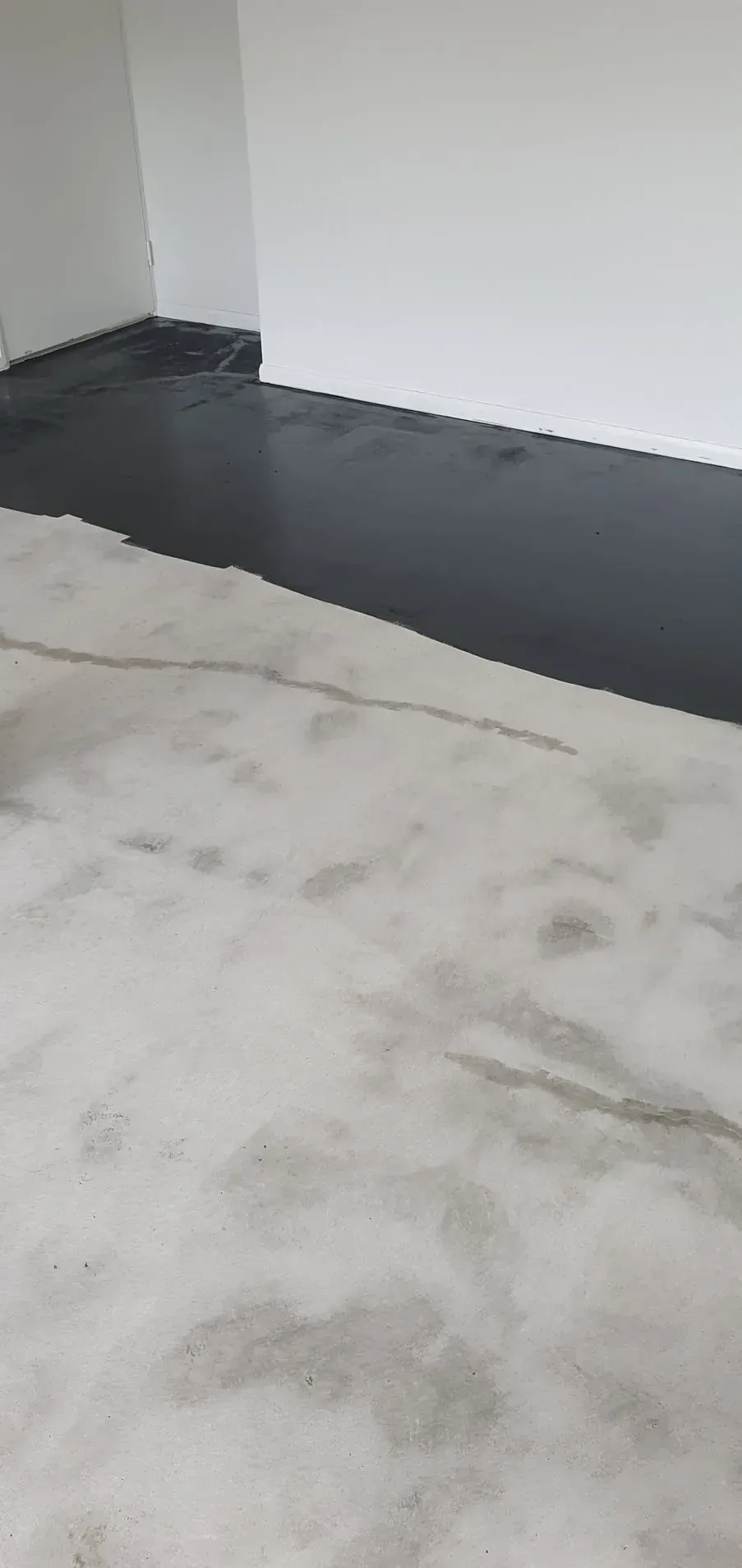 A Partially Painted Floor, Black on One Side and Concrete on the Other — Keppel Coatings in Pacific Heights, QLD