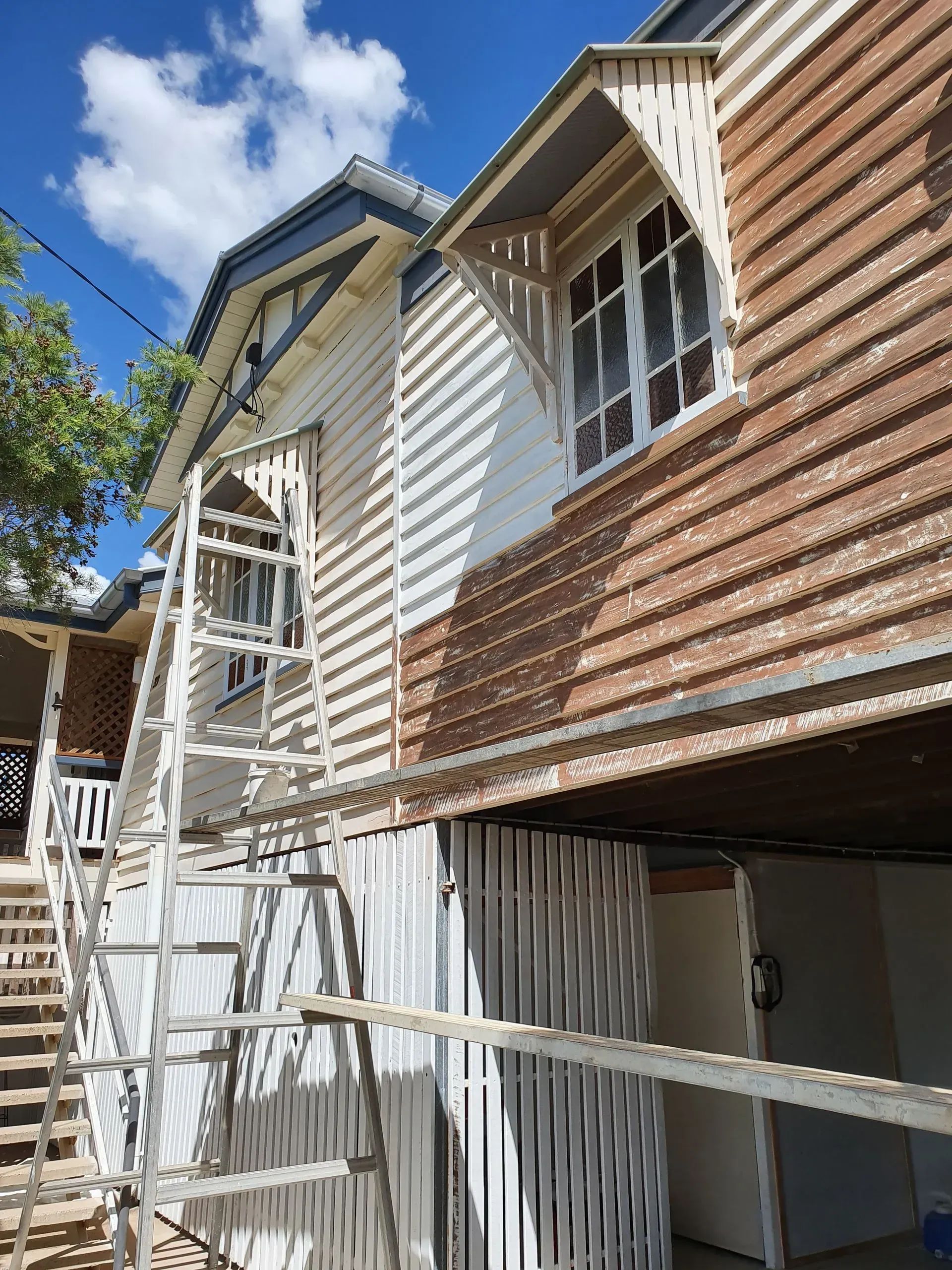 A Two-story House With White Siding and Brown Roof— Keppel Coatings in Pacific Heights, QLD