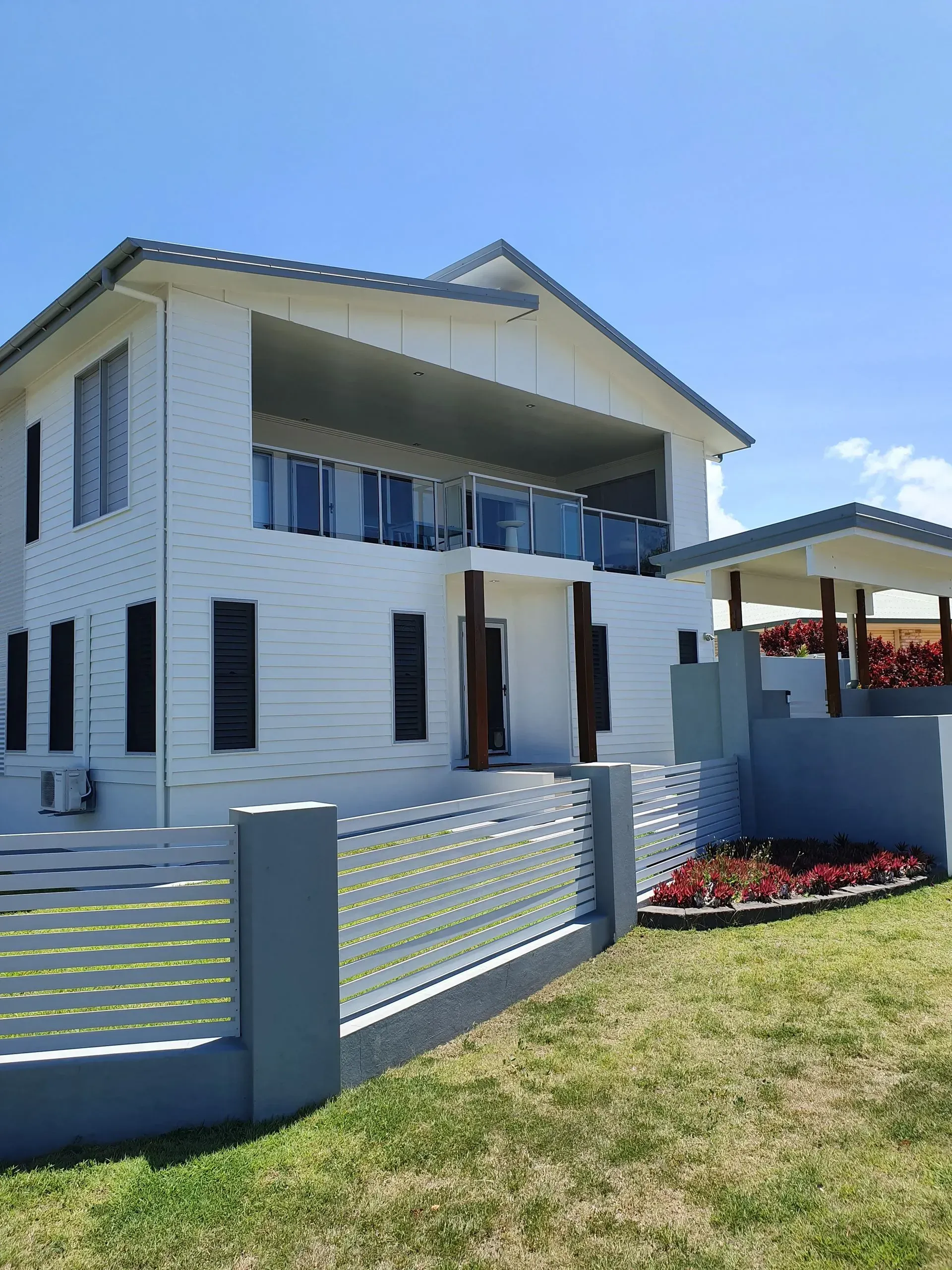 White Two-story House With Balcony, and Glass Railing — Keppel Coatings in Pacific Heights, QLD