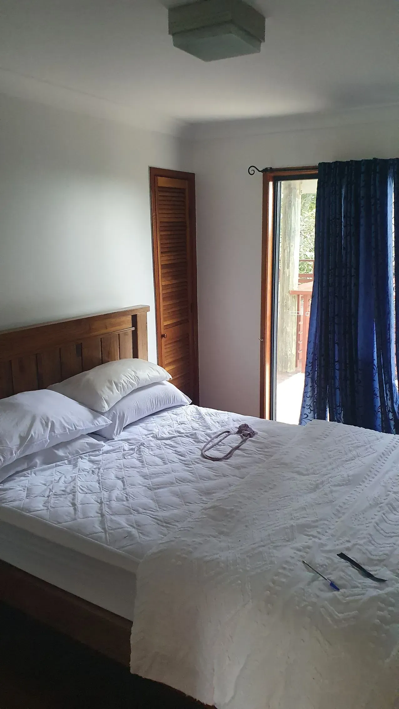 Bedroom With Wooden Bed, White Bedding — Keppel Coatings in Pacific Heights, QLD