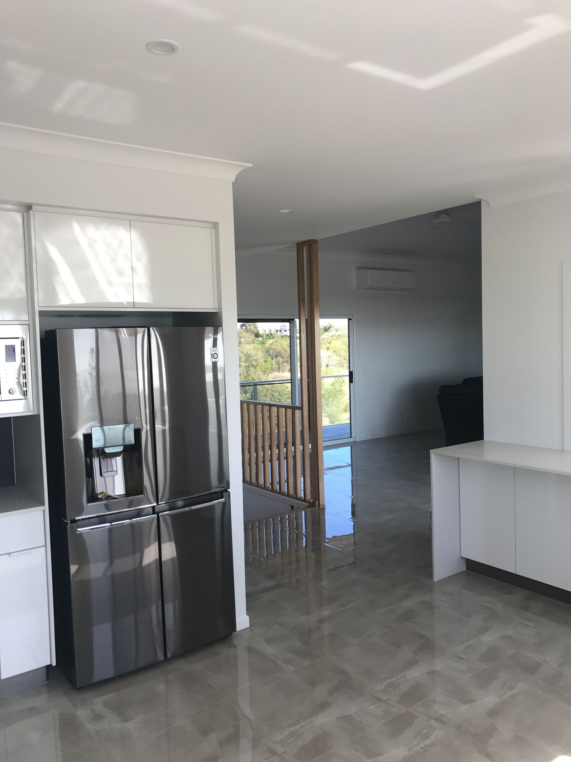 Modern Kitchen and Living Area With a Stainless Steel Refrigerator — Keppel Coatings in Pacific Heights, QLD