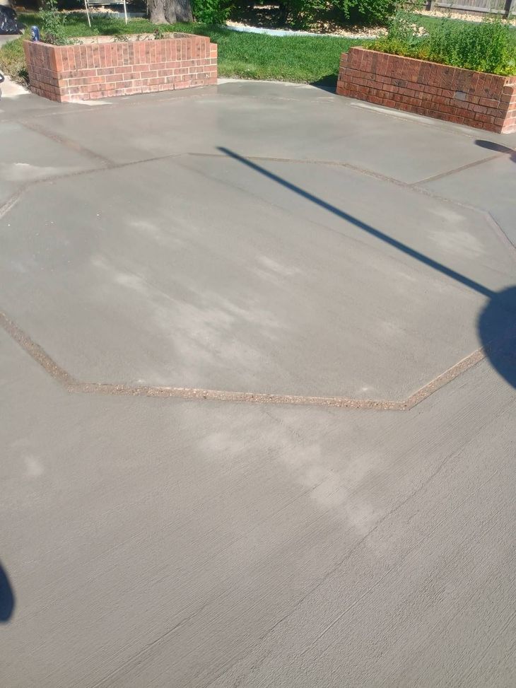 Concrete patio with brick planters and long shadows in sunlight