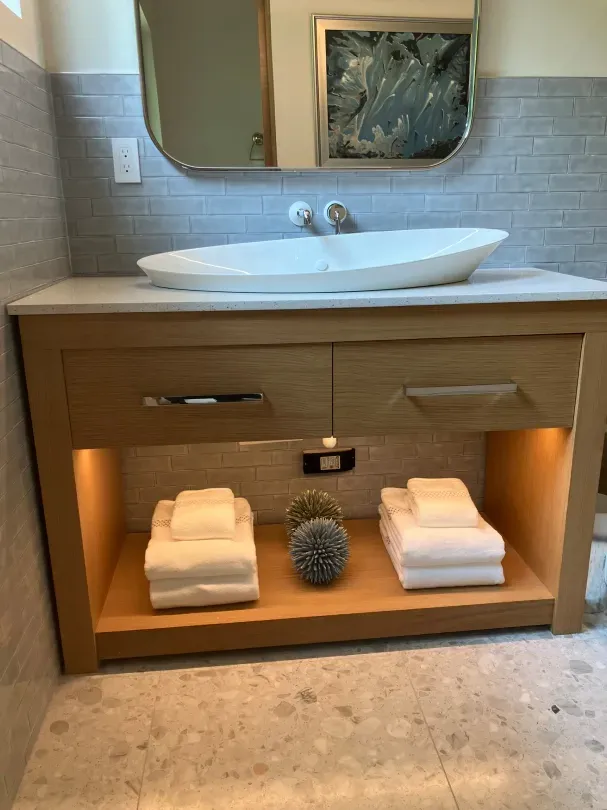 A bathroom with a sink and towels on a shelf