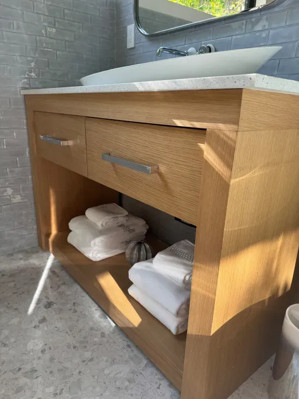 A bathroom with a wooden vanity and a sink