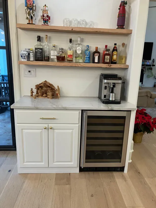 A kitchen with a bar and a wine fridge.