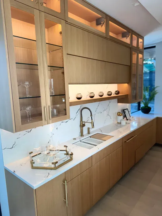 A kitchen with wooden cabinets , a sink , and a tray on the counter.