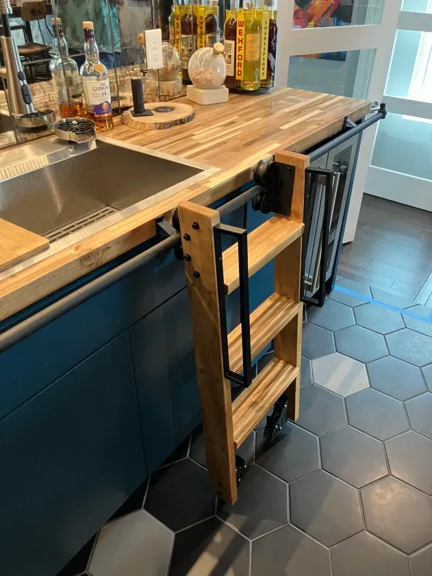 A wooden ladder is attached to a wooden counter in a kitchen.