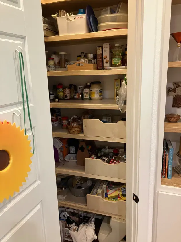 A pantry filled with lots of food and a sunflower on the door.