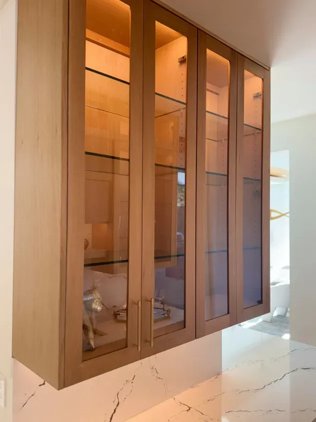 A kitchen with a lot of cabinets with glass doors