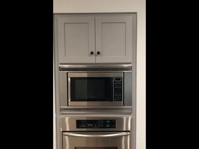A kitchen with stainless steel appliances and white cabinets.