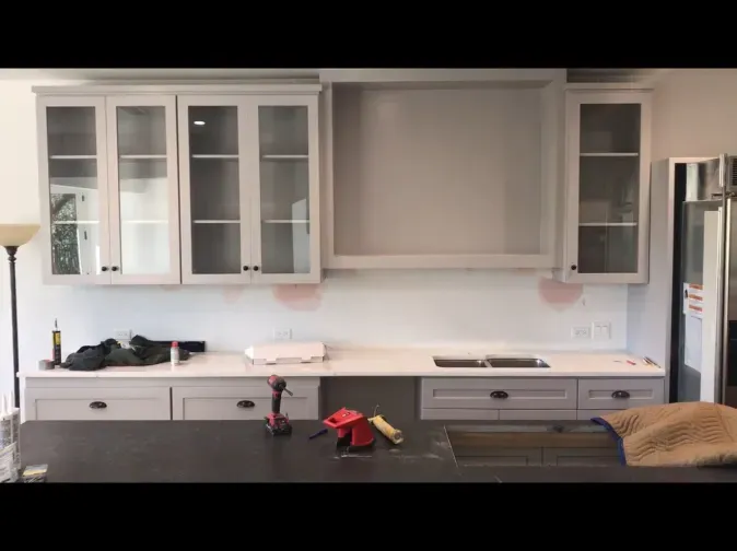 A kitchen with white cabinets and a black counter top.
