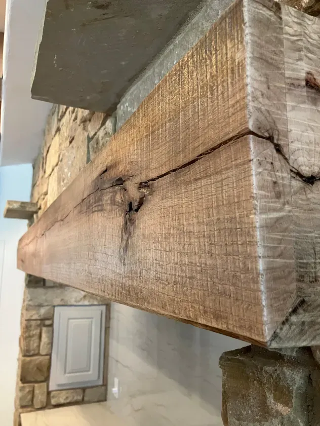 A wooden beam is sitting on top of a stone wall.