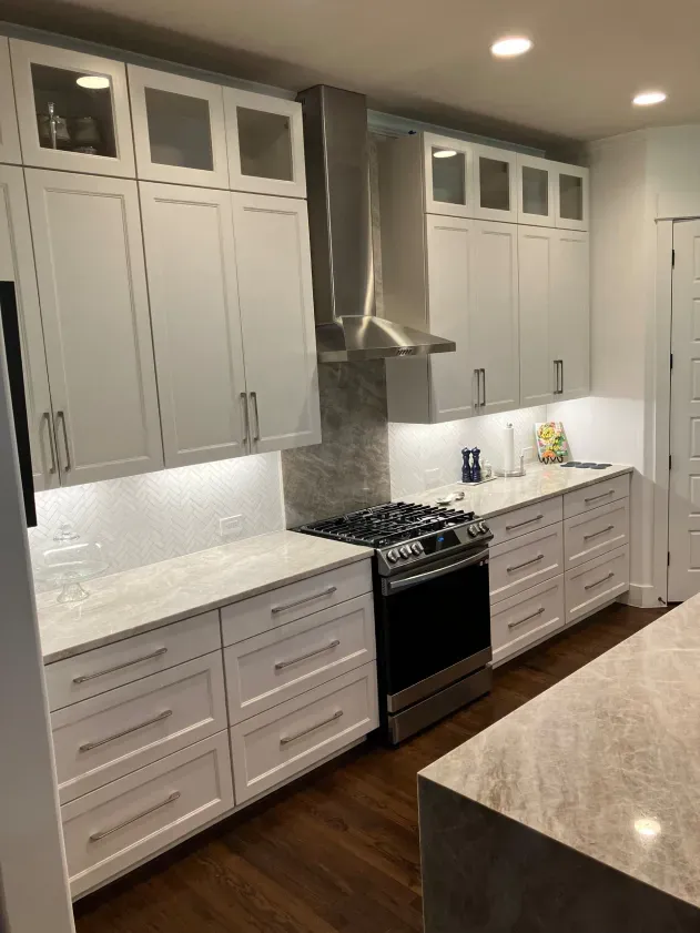 A kitchen with white cabinets and stainless steel appliances.