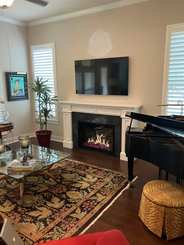 A living room with a fireplace and a piano.