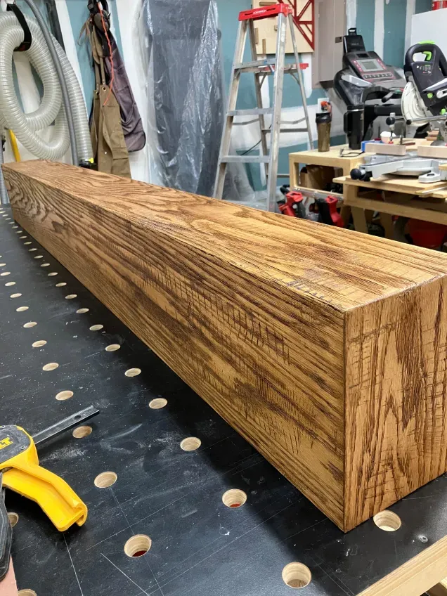 A long piece of wood is sitting on a table with holes in it