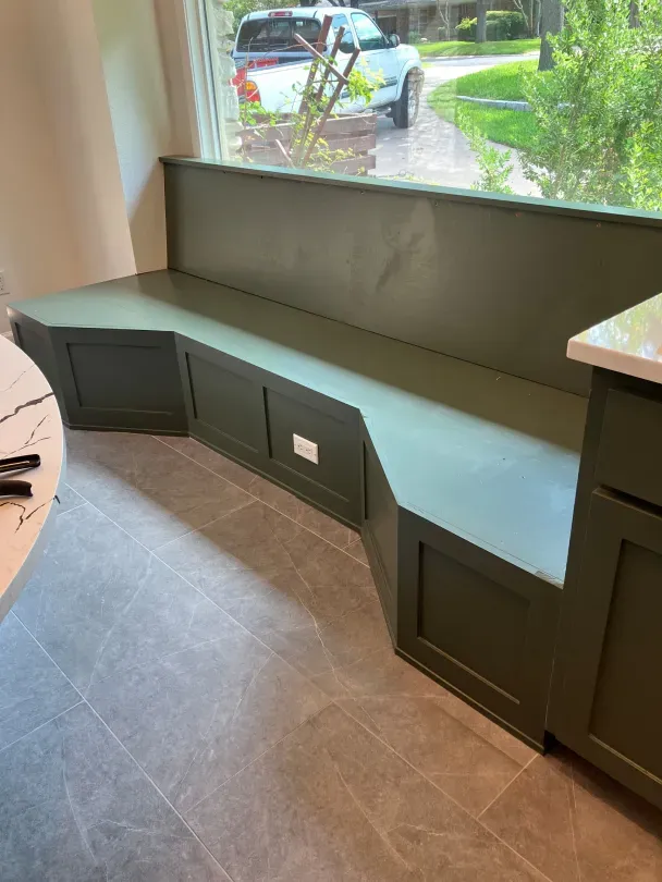 A kitchen with a bench in front of a window.