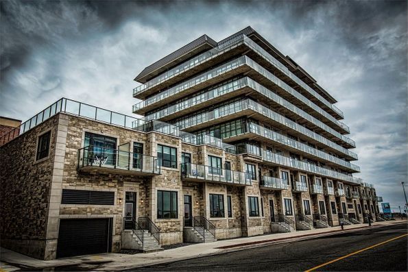 A large building with a lot of windows is sitting on the side of a street.