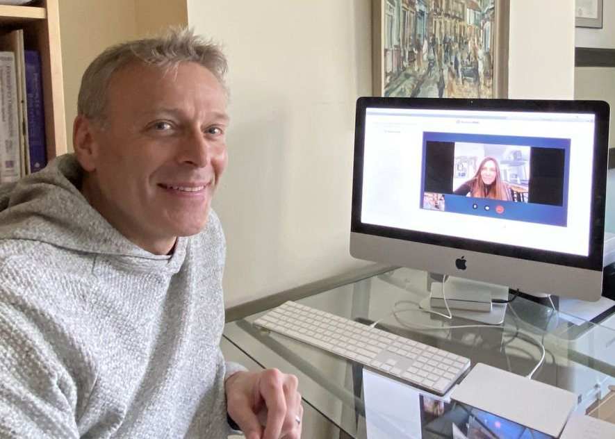 A man is sitting in front of an apple computer