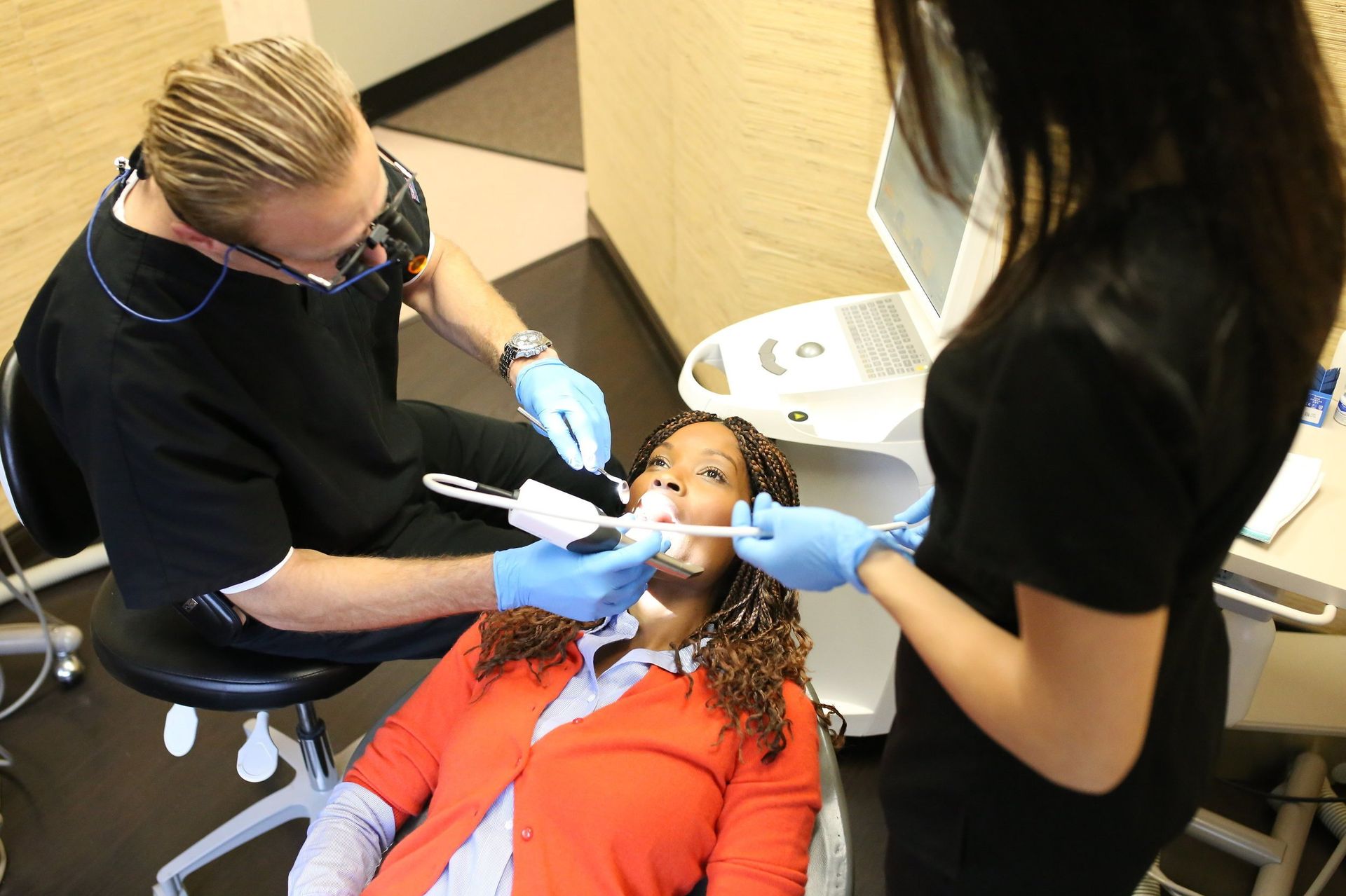 A woman is getting her teeth examined by a dentist