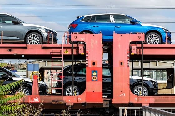 a blue car is on top of a red car carrier