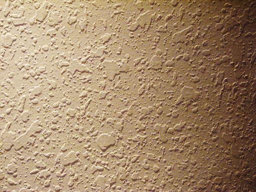 Textured beige wall with a speckled pattern.
