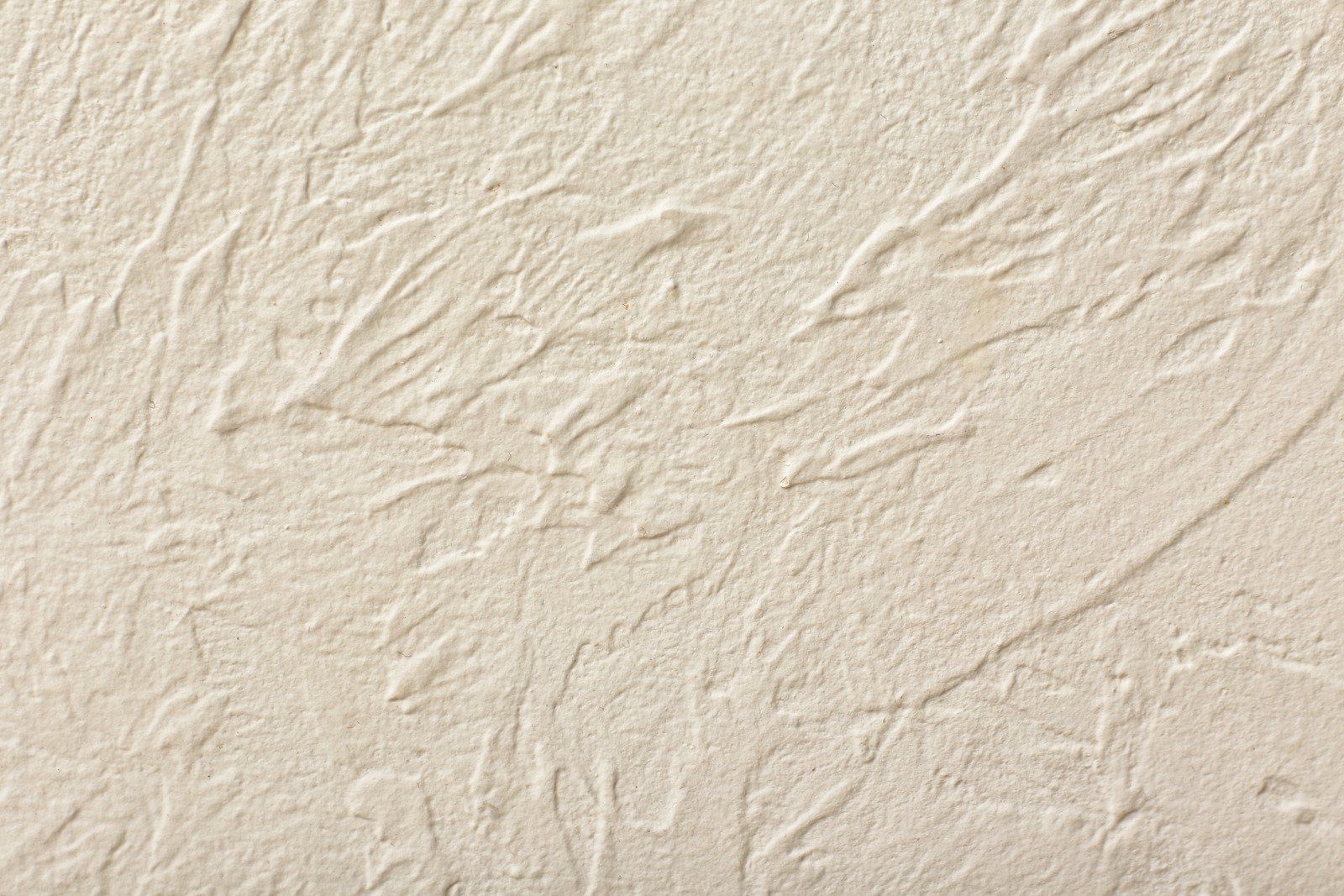 Close-up of beige-colored sand with textured patterns, likely from wind or water erosion.