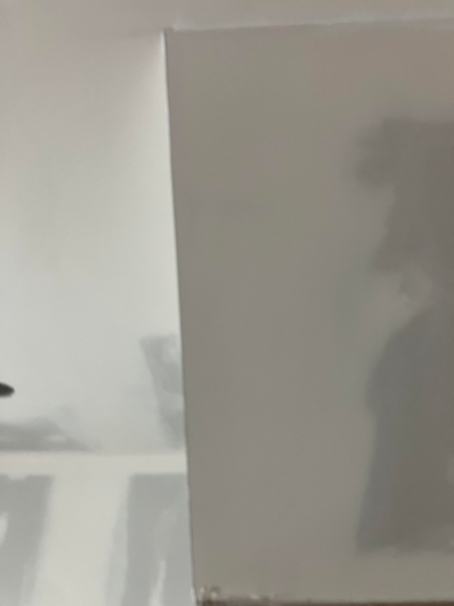 White drywall corner, unfinished, meeting a white ceiling.