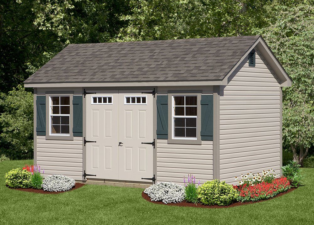 Tan shed with gray roof, teal shutters, double doors, and landscaping on a lawn.