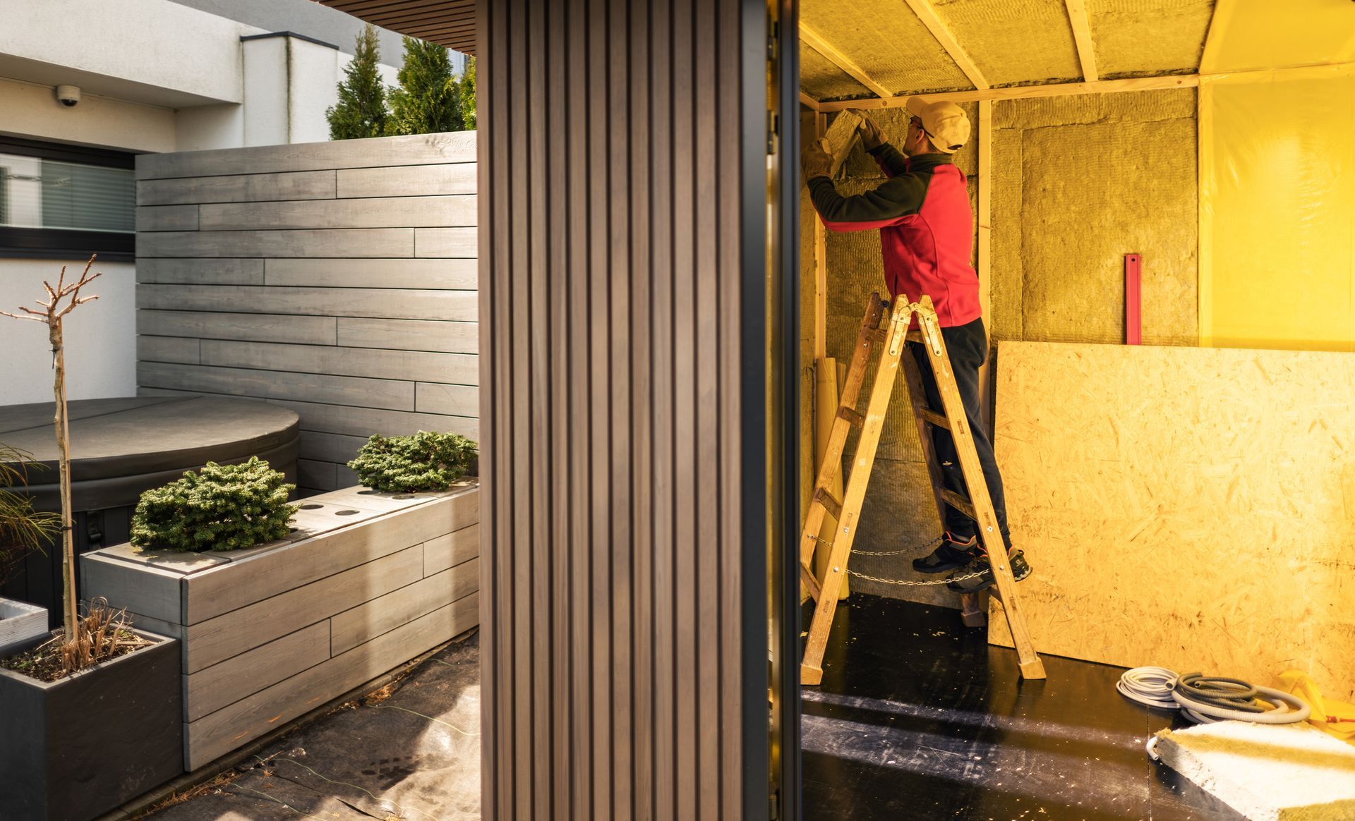 A contractor insulating a newly built storage shed.