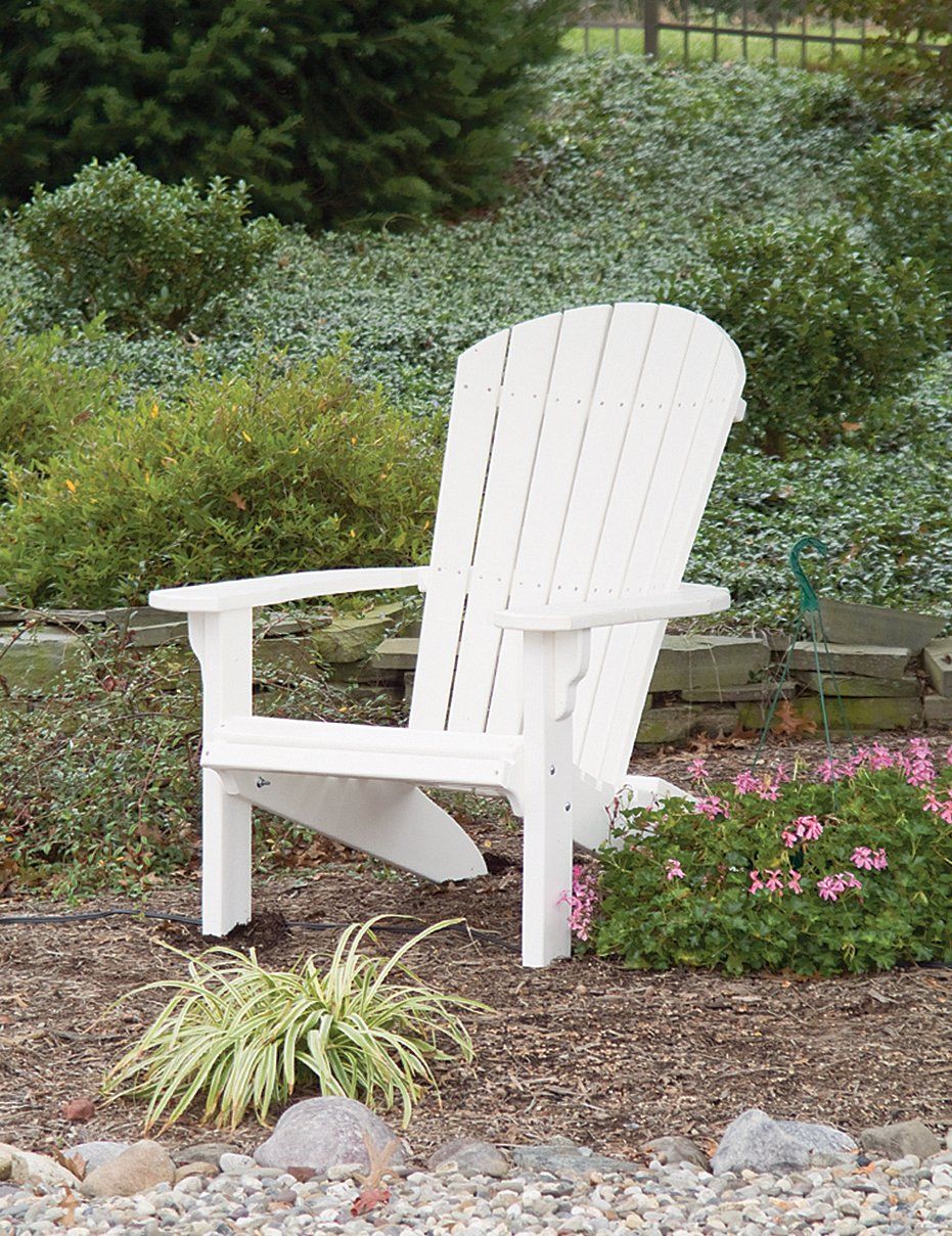 White Adirondack chair in a garden setting.