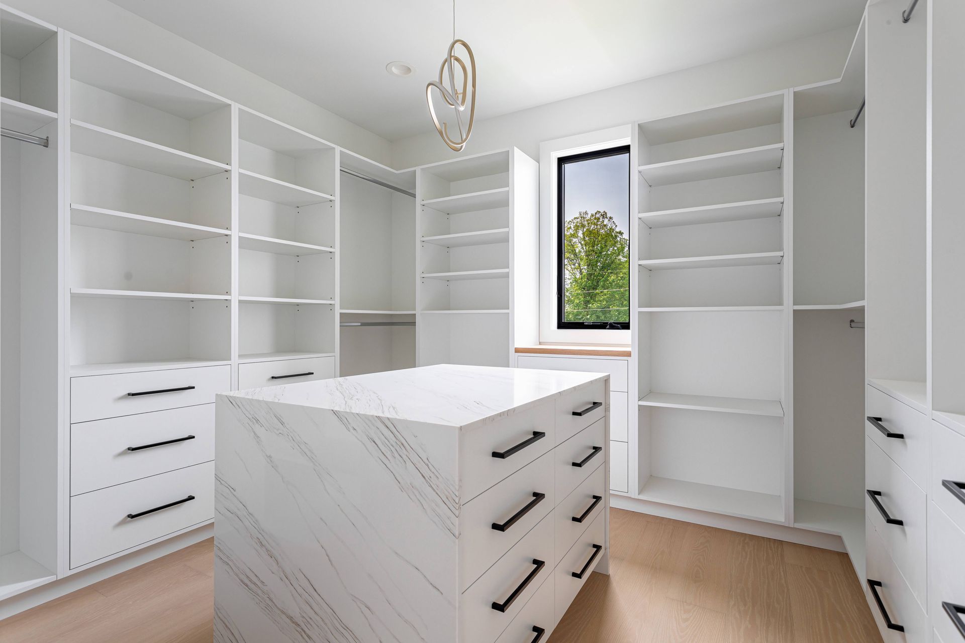 Modern walk-in closet interior with built-in shelves and storage island