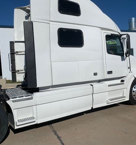 A white semi truck is parked in a parking lot.