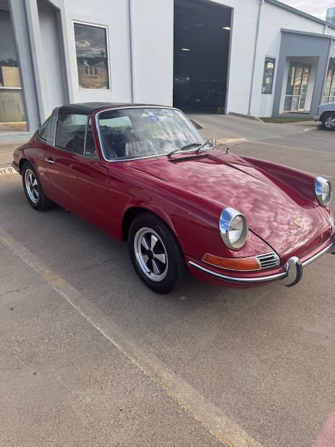 Maroon Porsche 911 Targa parked outside a building.