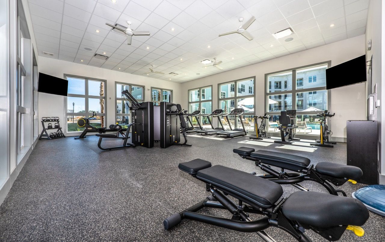 Modern community fitness center with treadmills, bikes, and weight machines.