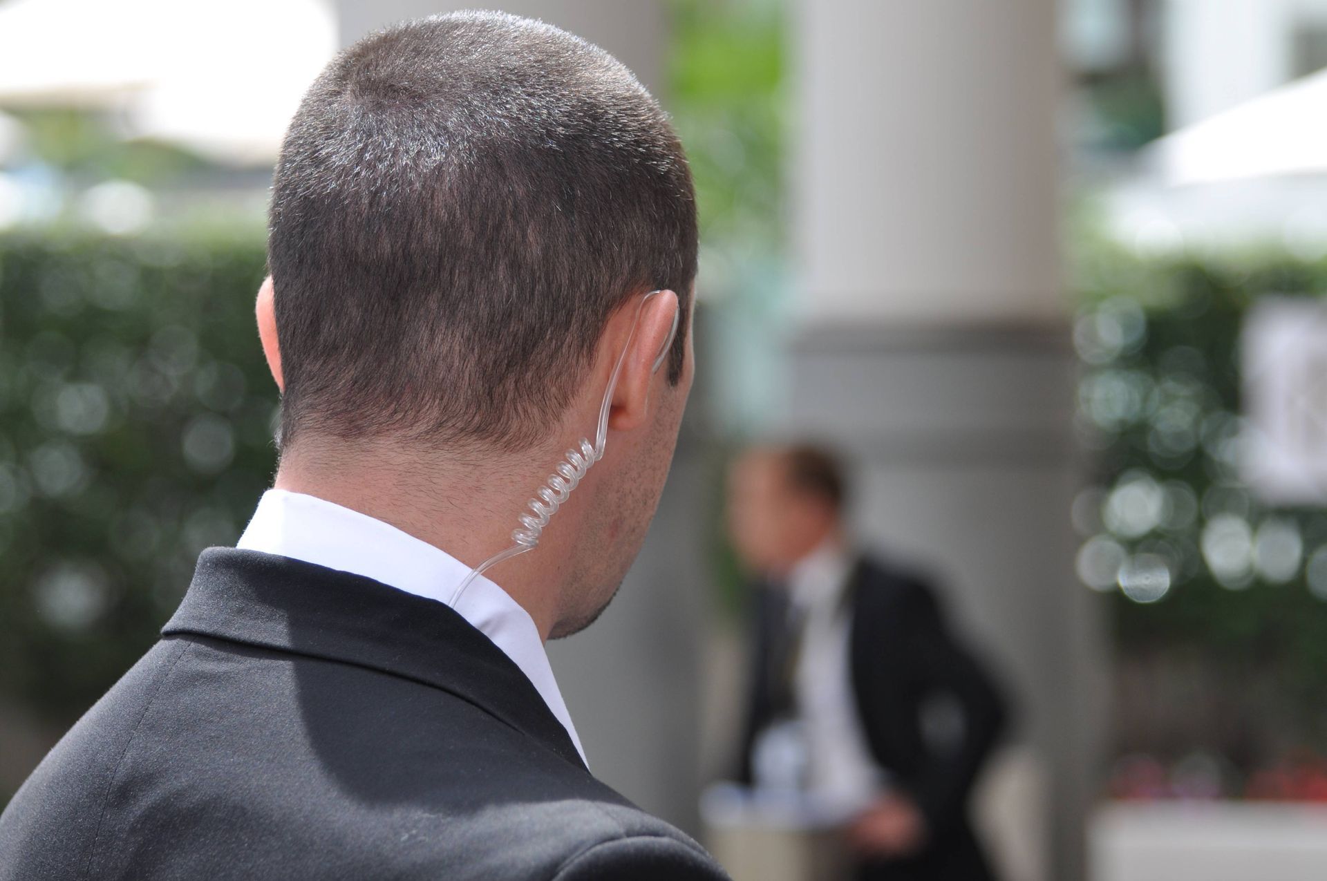 The back of an undercover agent’s head, wearing a visual earpiece