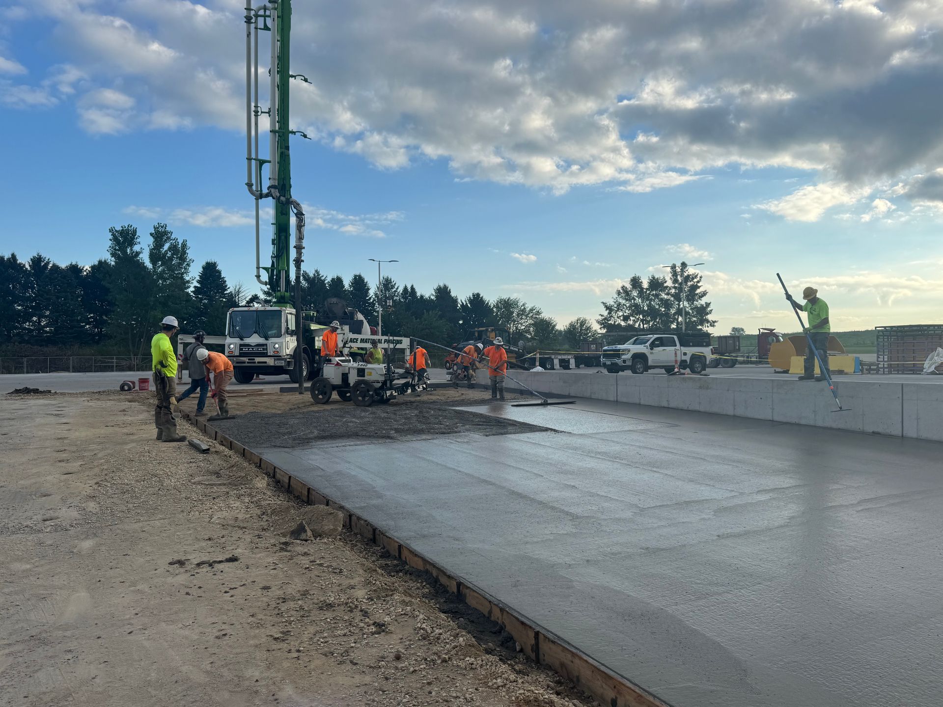 Construction workers repairing a large crack in concrete, using tools and wearing safety vests.