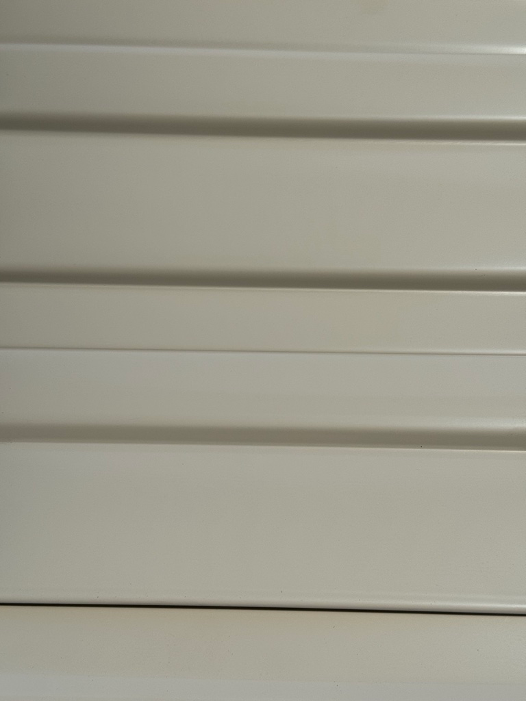 A close up of a white garage door with a striped pattern.