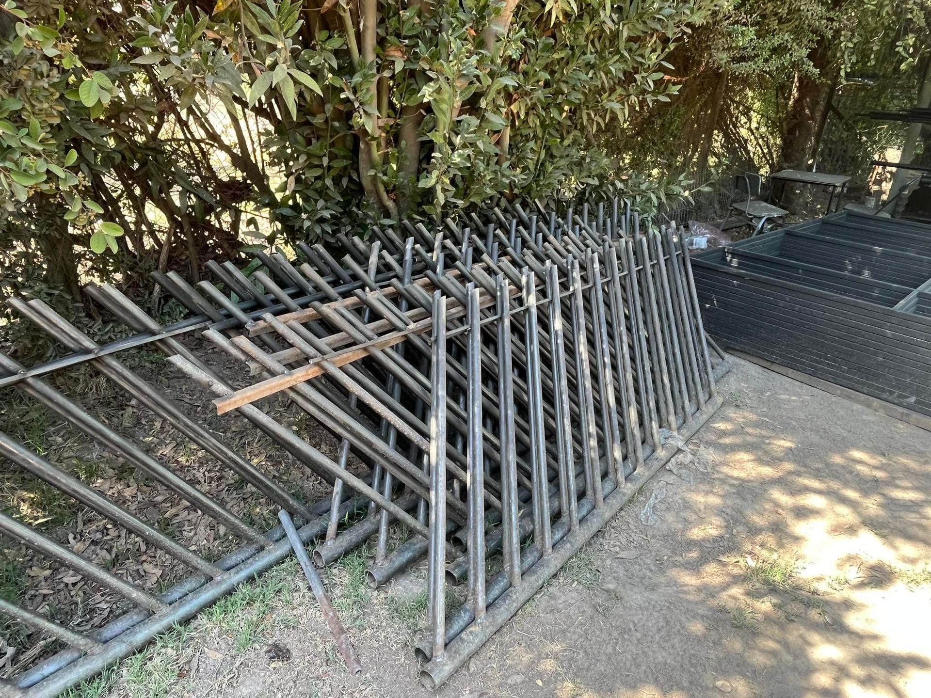 Paneles de cercado metálico apilados al aire libre.